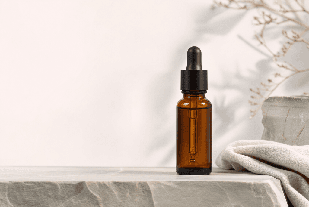 Even Serum bottle on a stone ledge with soft morning side-light and a single linen fold — calm editorial composition, product in the lower-right third